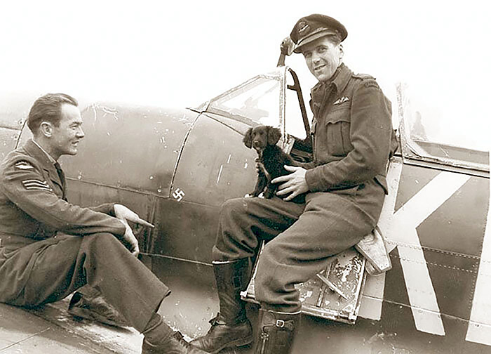 The mascot puppy named Lucy charms his way into the heart of pilot Roy Wosniak (R) and fitter Sergeant Delong.